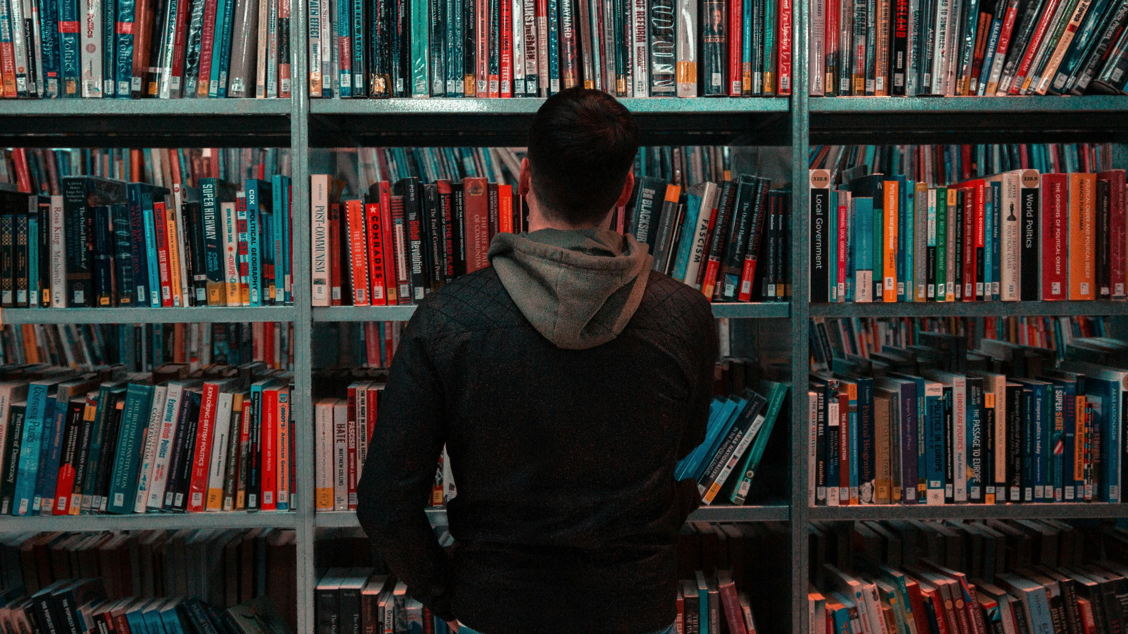 Image of man standing in front of a library shelf
